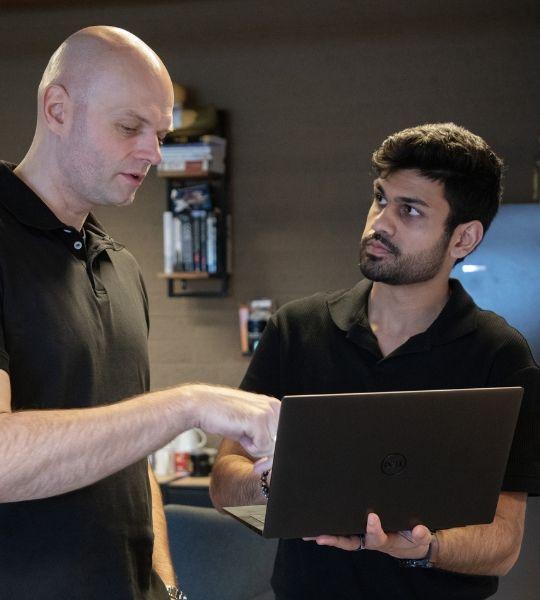 Twee collega's overleggen over iets op een laptop