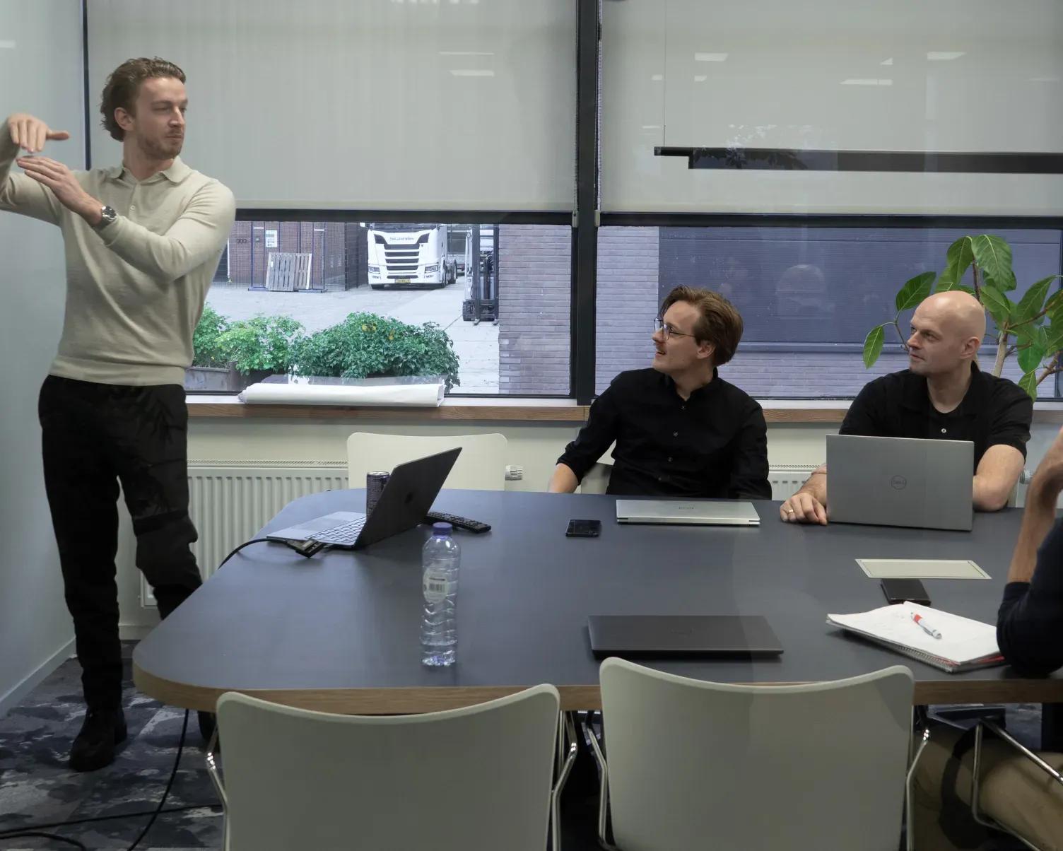 Tim licht iets toe aan collega's rond de vergadertafel